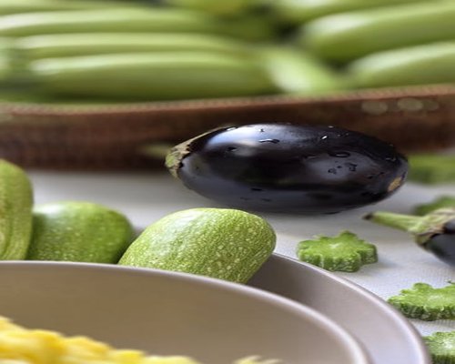 Fresh local vegetables and a glass of water on a kitchen table