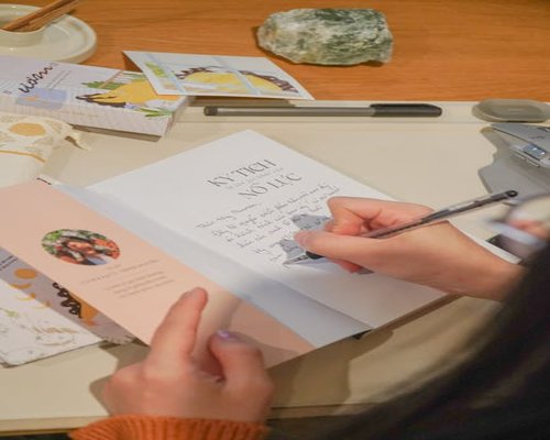 A person writing in a journal on a desk